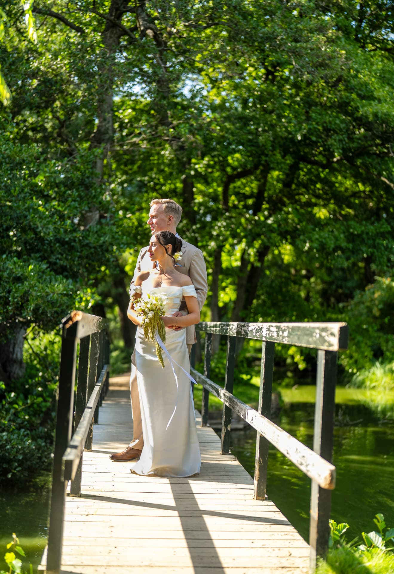 Bride and groom on the wooden garden bridge in the baroque gardens of Frederiksborg Slot, summer castle wedding photography Denmark